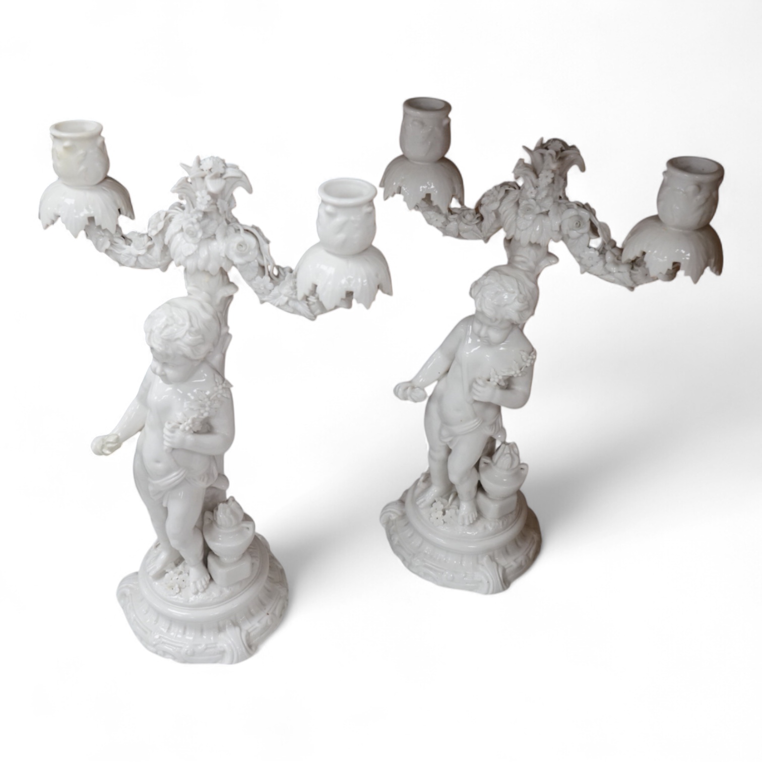 A pair of figural two branch candelabra, crossed swords marks, 36cm high